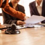 Lawyers reviewing divorce documents at a table with gavel and scales of justice.