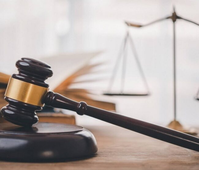 Judge’s gavel and legal scales beside open law book symbolizing wills and living trusts in California.