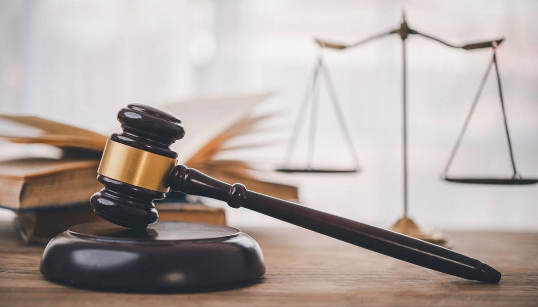 Judge’s gavel and legal scales beside open law book symbolizing wills and living trusts in California.