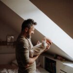 Father holding baby while considering child custody modification in California