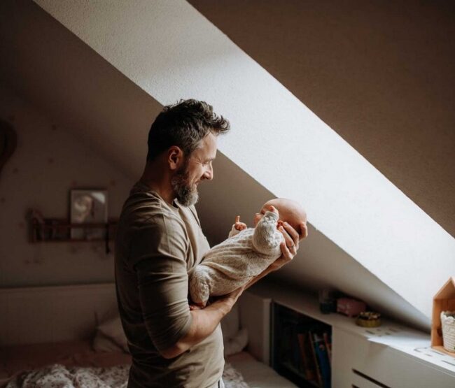 Father holding baby while considering child custody modification in California